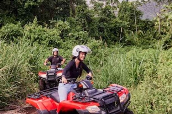 a man riding a motorcycle down a dirt road