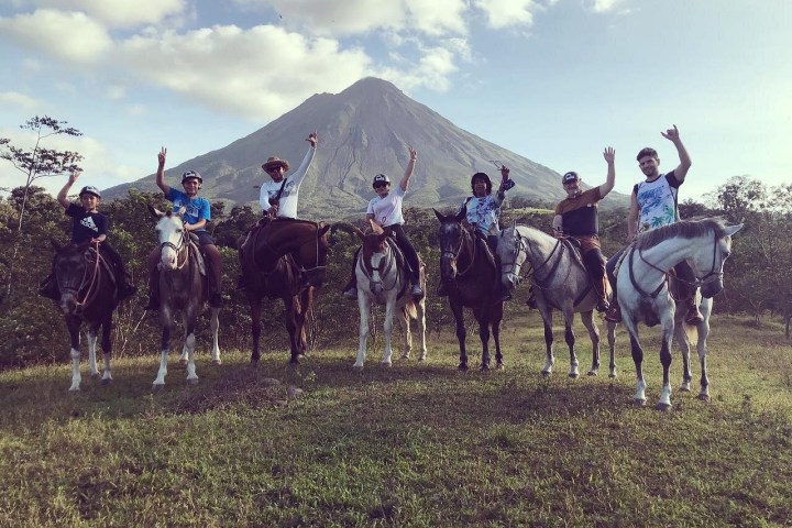 a group of people riding a horse in a field